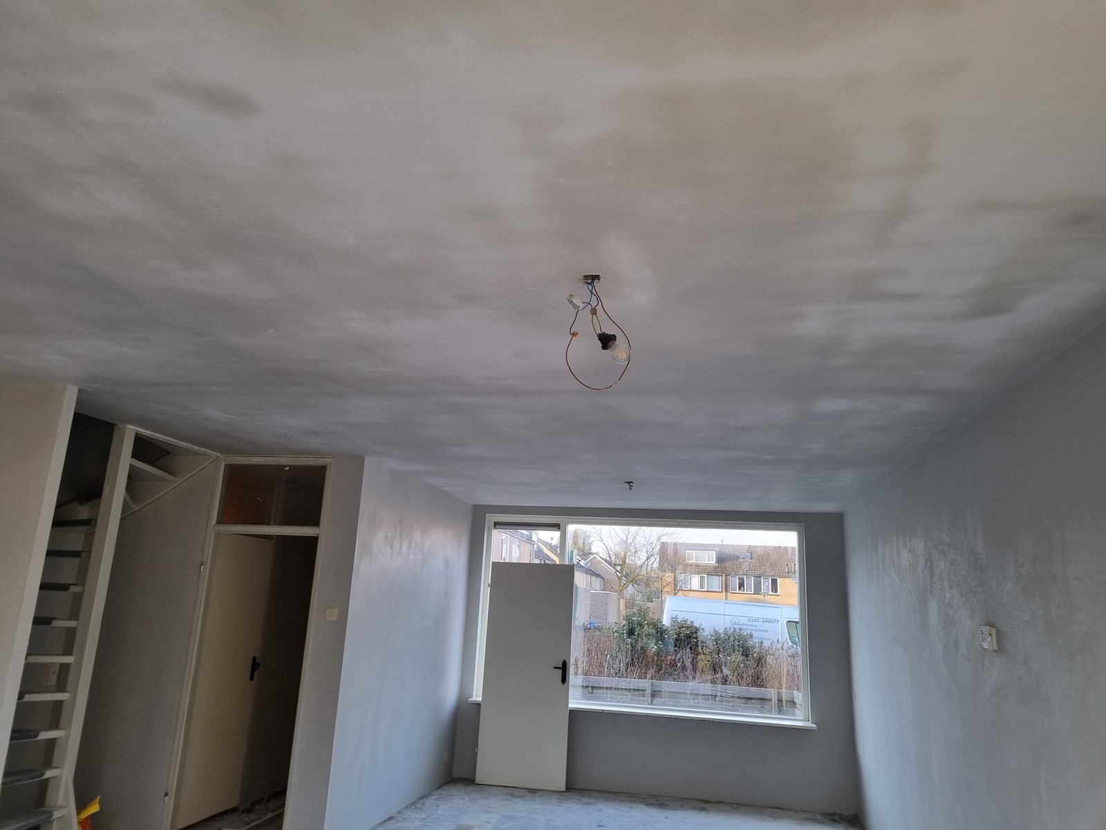 Kamer met vers gestucte wanden en plafond, klaar voor afwerking